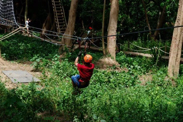 Du khách đang tham gia trò chơi trượt qua dây thừng tại Công viên Ozo