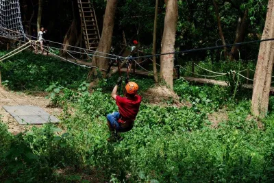 Du khách đang tham gia trò chơi trượt qua dây thừng tại Công viên Ozo