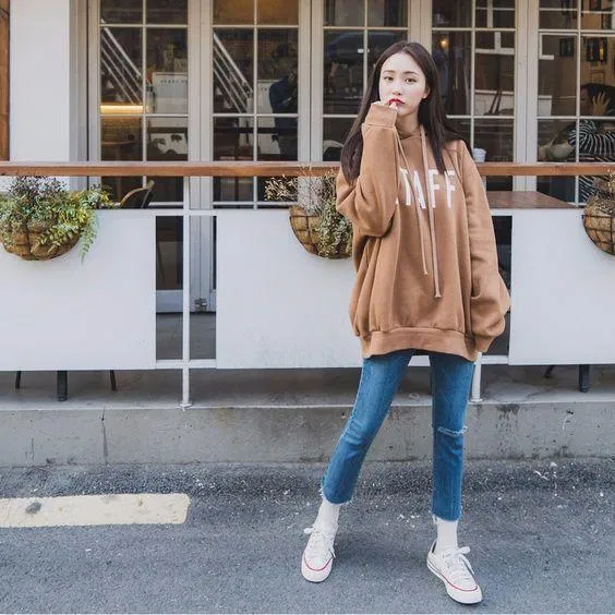Hoodie nâu cafe in chữ đậm phong cách Tây cùng chiếc quần jean skinny xanh và đôi sneaker converse huyền thoại tạo nên một set đồ hoàn hảo. ( nguồn ảnh internet.) Hoodie nâu cafe in chữ đậm phong cách Tây cùng chiếc quần jean skinny xanh và đôi sneaker converse huyền thoại tạo nên một set đồ hoàn hảo. ( nguồn ảnh internet.)