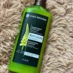 Dầu gội giảm rụng tóc Yves Rocher Anti Hair Loss Stimulating Shampoo có bao bì màu xanh lá cây, tem dán mặt trước in hình một nhành hoa Lupine trắng đẹp tinh tế, nổi bật (ảnh: internet).