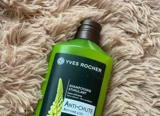 Dầu gội giảm rụng tóc Yves Rocher Anti Hair Loss Stimulating Shampoo có bao bì màu xanh lá cây, tem dán mặt trước in hình một nhành hoa Lupine trắng đẹp tinh tế, nổi bật (ảnh: internet).