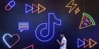 Image: FILE PHOTO: Man walks past a sign of ByteDance s app TikTok, known locally as Douyin, at an expo in Hangzhou