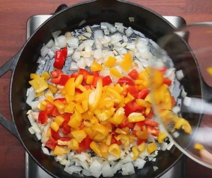 Thực hiện xào hành tây, tỏi và ớt chuông đến khi chín mềm (Ảnh: Internet)