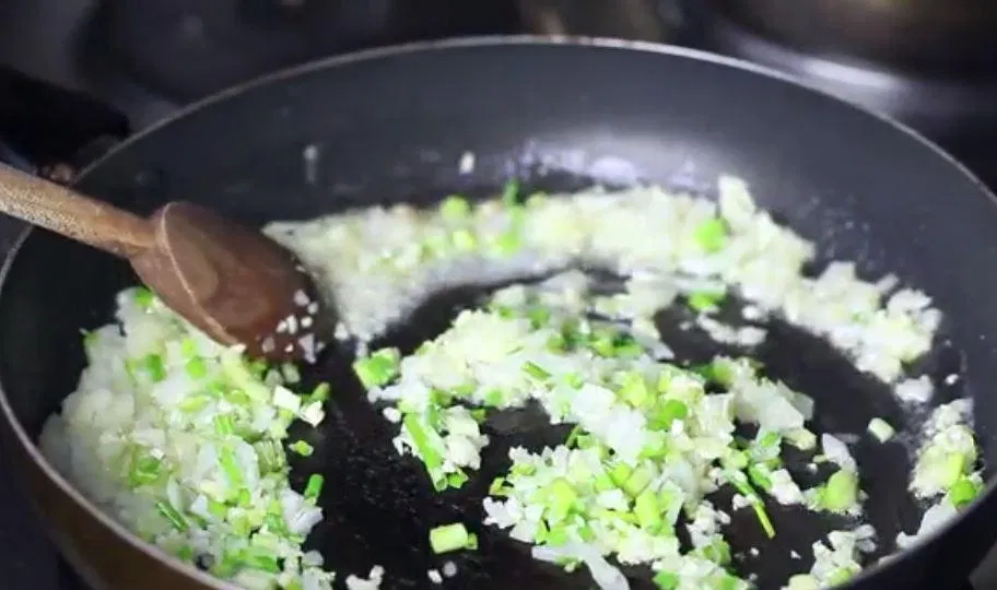 Thực hiện xào tỏi và hành lá đến khi dậy mùi thơm (Ảnh: Internet)