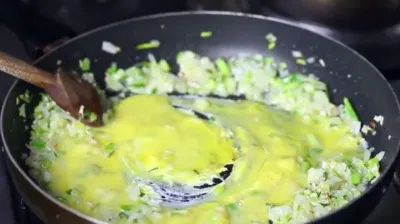 Đổ trứng vào chảo và tiếp tục khuấy đều Đổ trứng vào chảo và tiếp tục khuấy đều (Ảnh: Internet)