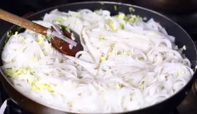 Đổ mì vào chảo và tiếp tục xào với nước xốt me Đổ mì vào chảo và tiếp tục xào với nước xốt me (Ảnh: Internet)