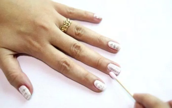 Dùng nước tẩy móng lau sạch phần sơn dính trên ngón tay lau móng