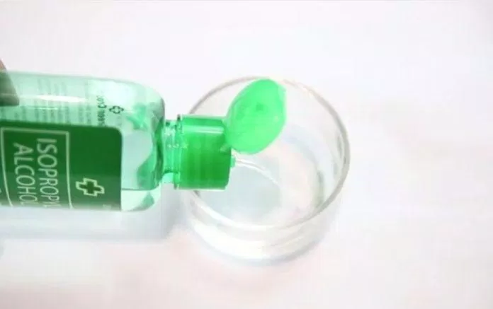 Đổ một chút cồn y tế vào nắp chai hoặc một cái cốc nhỏ pha cồn