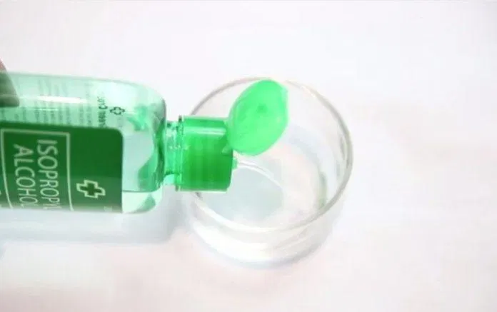 Đổ một chút cồn y tế vào nắp chai hoặc một cái cốc nhỏ pha cồn