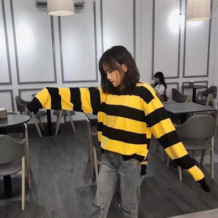 Áo len sọc vàng đen với quần jeans màu khói.  (nguồn ảnh: internet.)