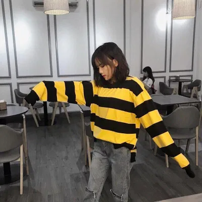 Sweater sọc vàng đen phối quần jean màu khói. (nguồn ảnh: internet.) Sweater sọc vàng đen phối quần jean màu khói. (nguồn ảnh: internet.)