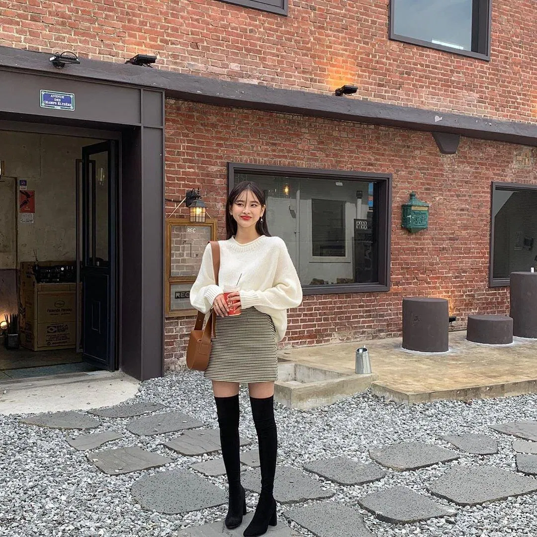 Kết hợp với boots dài ngang đùi vừa ấm áp lại vô cùng cá tính áo len dáng rộng và chân váy