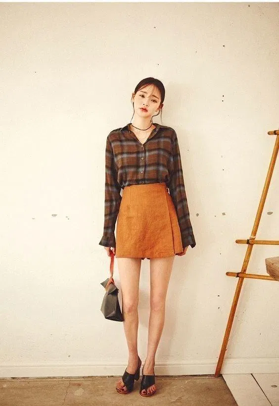 Áo sơ mi sọc tối màu mix chân váy vàng nổi bật. (nguồn ảnh: internet) Áo sơ mi sọc tối màu mix chân váy vàng nổi bật. (nguồn ảnh: internet)