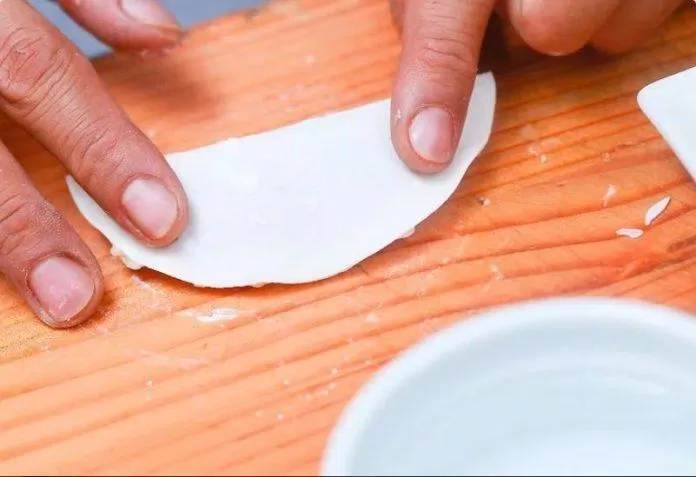 Gấp đôi vỏ bánh, dùng tay nắn viền sao cho phần nhân được bịt kín hoàn toàn gói há cảo