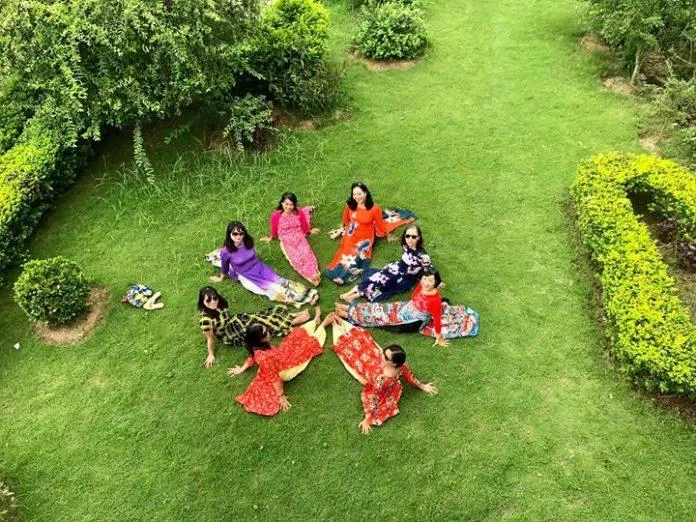 Các cô, các chị chụp ảnh với chiếc áo dài thướt tha trên nền cỏ xanh tại khu sinh thái Ngọc Linh