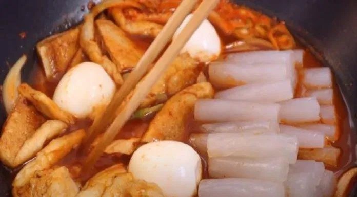 Thêm bánh gạo, chả cá, trứng và hành vào đun lửa nhỏ (Nguồn: Internet)