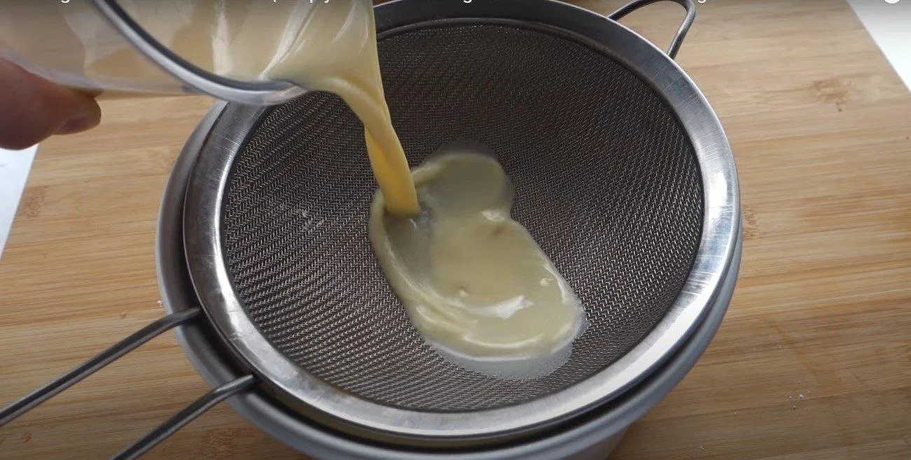 Dùng rây lọc qua phần bánh Flan để loại bỏ bọt khí (nguồn: ) Dùng rây lọc qua phần bánh Flan để loại bỏ bọt khí (nguồn: )