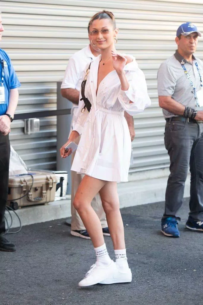 Bella Hadid cũng không hề lép vế với cô em mình khi diện chiếc váy sơ mi trắng trễ vai thắt eo. (nguồn ảnh: Internet)