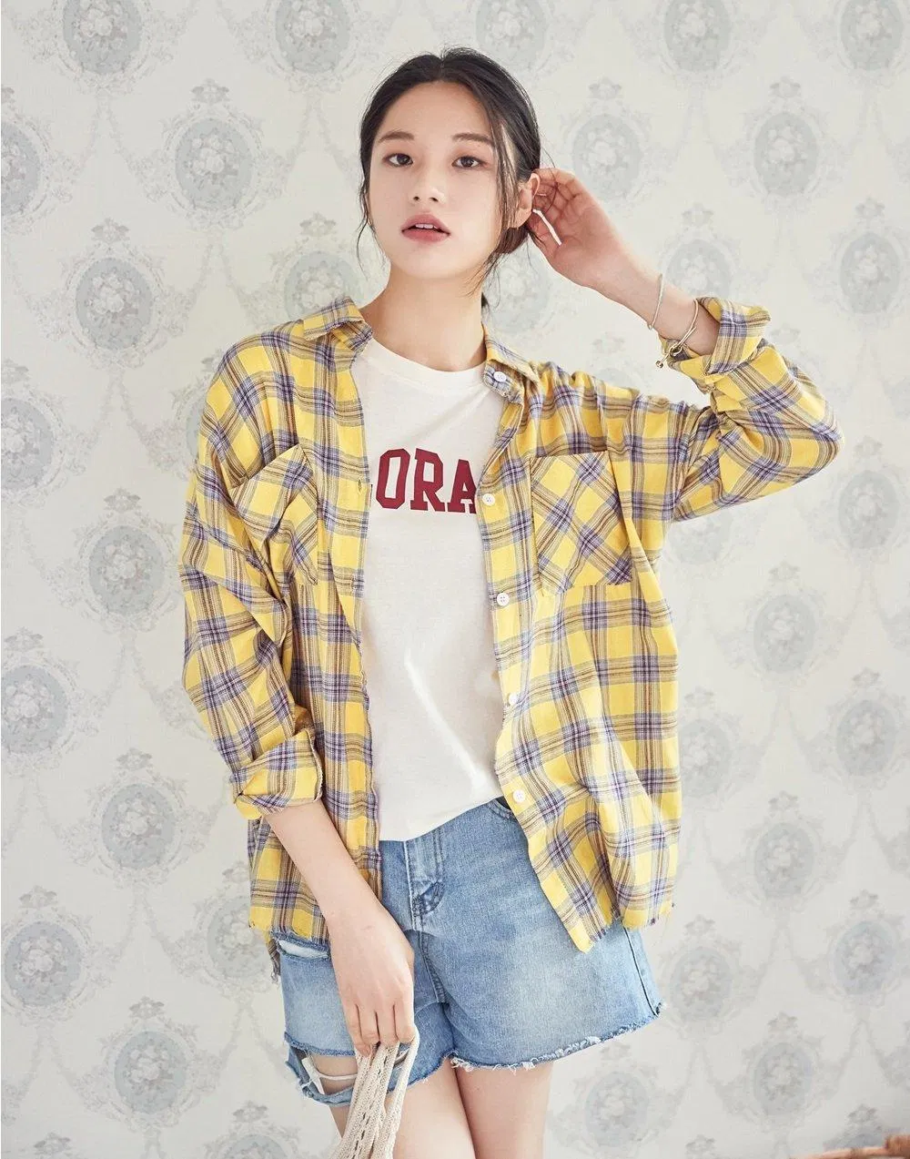 Dịu dàng, bắt mắt với áo sọc kẻ vàng mix layer áo thun trắng in chữ và quần short jean. (nguồn ảnh: Internet)