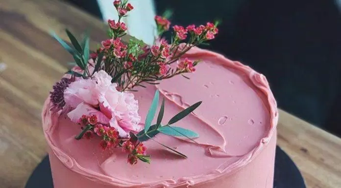 Bánh kem được trang trí bằng tông màu đỏ của mâm xôi và hoa tươi (Ảnh: internet)