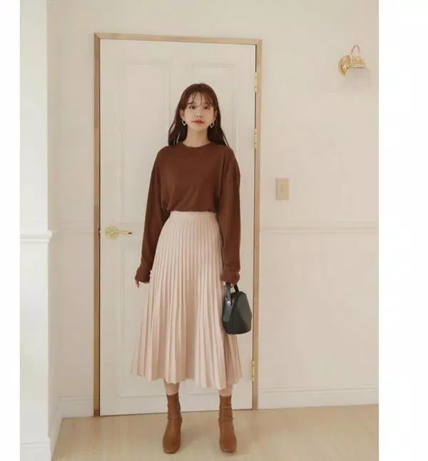 Thanh lịch với boot cổ cao và chân váy xếp li (Nguồn: Internet) Thanh lịch với boot cổ cao và chân váy xếp li (Nguồn: Internet)