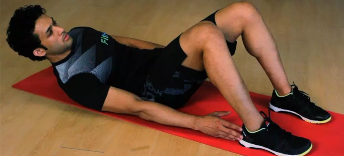 Động tác "chạm gót" khi nằm ngửa trên sàn (Ảnh: Internet). Động tác "chạm gót" khi nằm ngửa trên sàn (Ảnh: Internet).