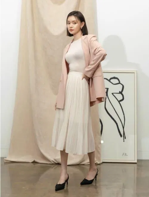 Chân váy midi xếp ly kèm theo áo blazer nổi bật (Nguồn: Internet) Chân váy midi xếp ly kèm theo áo blazer nổi bật (Nguồn: Internet)