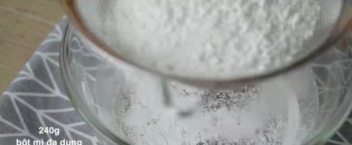 Rây bột vào hỗn hợp nước màu, đường và baking soda pha sẵn. (Ảnh: Internet)