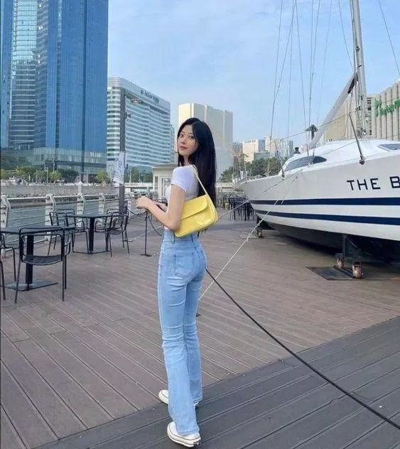 Túi da màu sắc nổi bật làm outfit quần jean- áo thun không còn tẻ nhạt nữa (ảnh: internet)