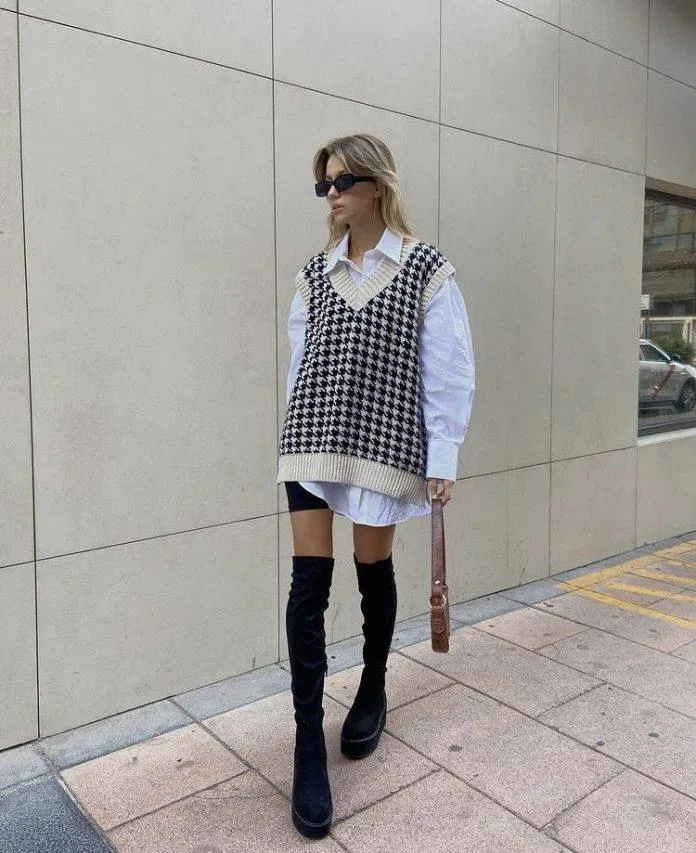 Áo sơ mi trắng form oversized kết hợp cùng áo gile len và boots cao cổ(Nguồn: Internet).