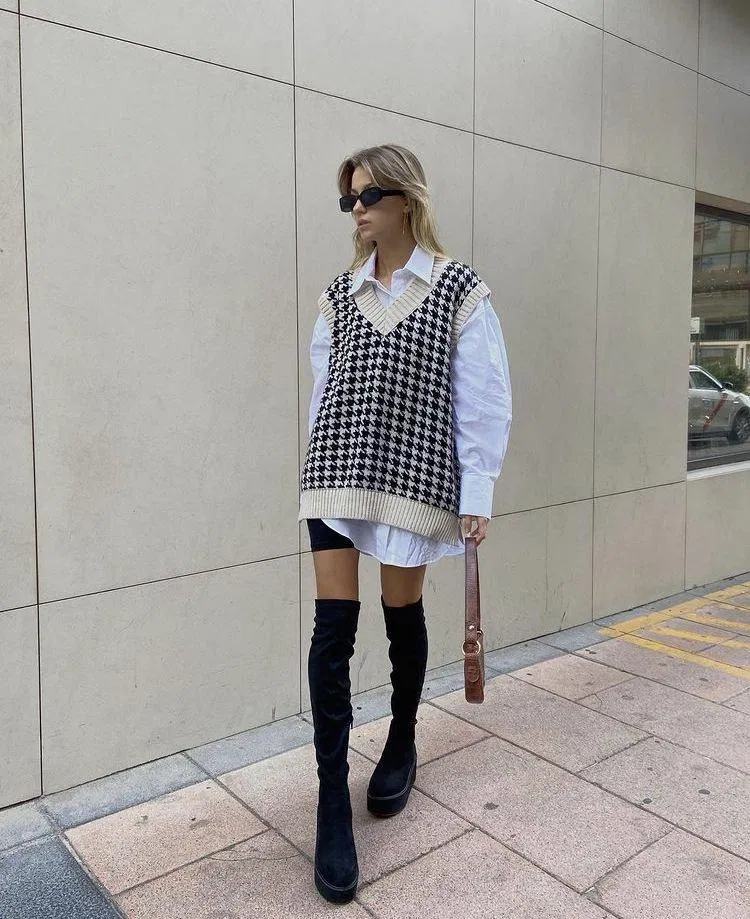 Áo sơ mi trắng form oversized kết hợp cùng áo gile len và boots cao cổ(Nguồn: Internet).