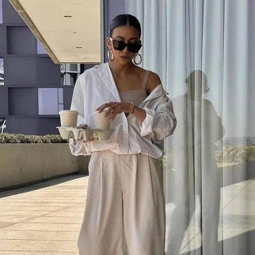 Áo sơ mi hở một bên vai kết hợp cùng áo hai dây và quần tây ống rộng (nguồn: Internet)