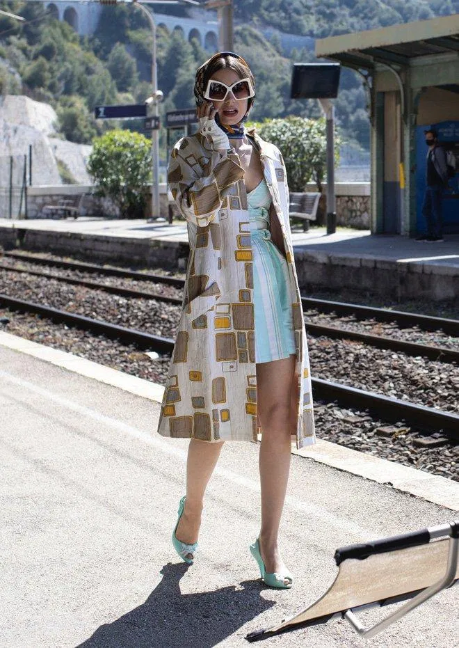 Chiếc váy xanh mint cùng giày cao gót được mix match tinh tế với Trench coat dáng dài họa tiết khối hộp. (nguồn ảnh: ELLE) Chiếc váy xanh mint cùng giày cao gót được mix match tinh tế với Trench coat dáng dài họa tiết khối hộp. (nguồn ảnh: ELLE)