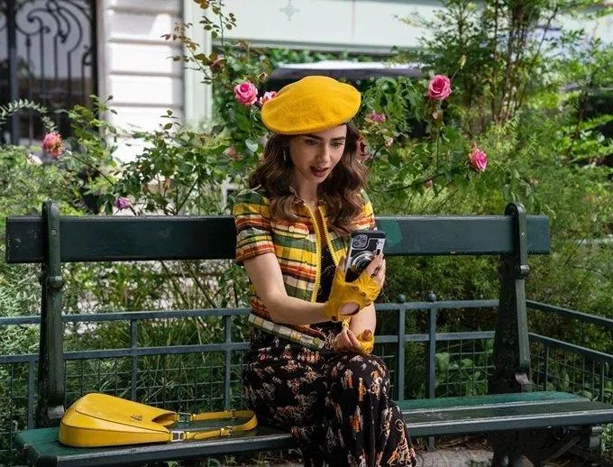 Bộ Jumpsuit đen kết hợp với chiếc áo khoác kẻ caro nhiều màu kèm mũ beret và túi Prada vàng. (nguồn ảnh: Internet) Bộ Jumpsuit đen kết hợp với chiếc áo khoác kẻ caro nhiều màu kèm mũ beret và túi Prada vàng. (nguồn ảnh: Internet)