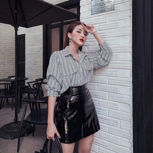 Chân váy da kết hợp cùng áo sơ mi thanh lịch, sang trọng.