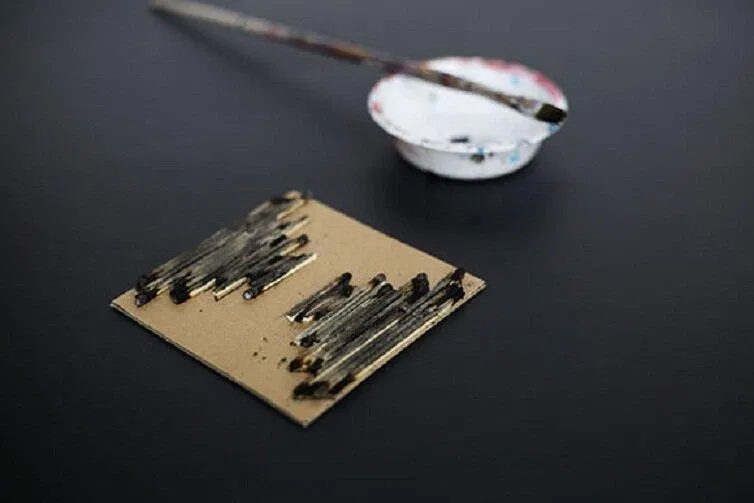 Dán những que diêm theo hình mẫu và sơn màu đen (Nguồn: Internet) Dán những que diêm theo hình mẫu và sơn màu đen (Nguồn: Internet)