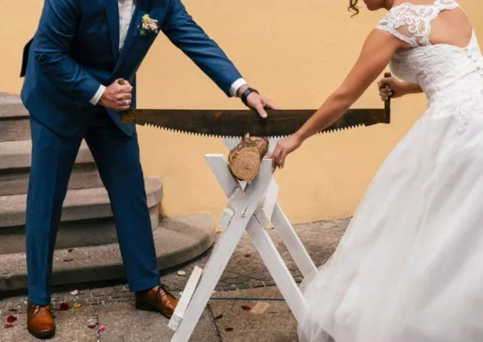 Cô dâu và chú rể cùng nhau cưa một khúc gỗ (Ảnh: Internet)