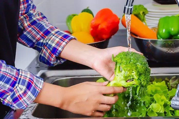 Rửa sạch rau củ quả dưới vòi nước đang chảy để loại bỏ các hóa chất bên ngoài (Ảnh: Internet).
