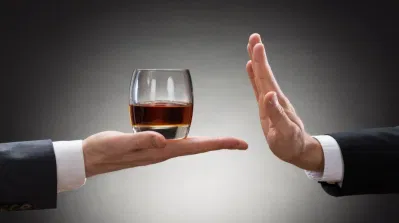 Rượu không tốt cho sự phục hồi cơ thể sau tập luyện (Ảnh: Internet). Close-up Of Businessman Hand Reject A Glass Of Whisky Offered By Businessperson