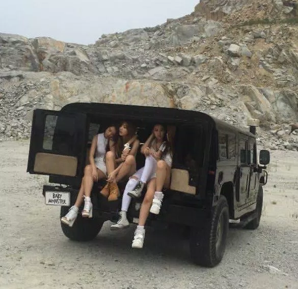Các thành viên ngồi trên xe với đạo cụ có chữ "BABY MONSTER" (Ảnh: instagram @axis_sinxity)