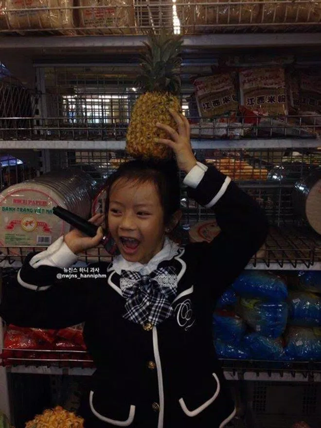 Hanni cầm micro trong siêu thị Việt Nam đội trên đầu cùng trái dứa