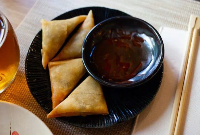 Traditional Portuguese dish with Asian twist - samosas or chamucas filled with spicy curry leaves served with sauce