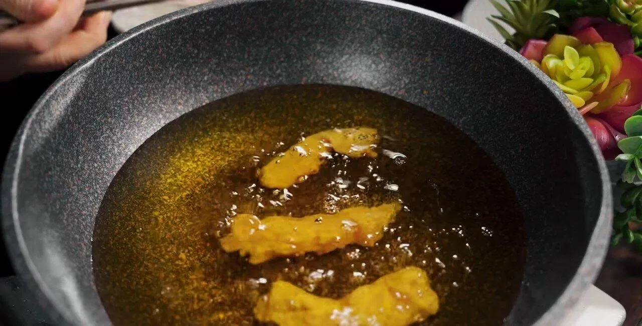 Đợi dầu nóng mới bỏ ức gà vào (Ảnh YouTube: Cô Ba Bình Dương). Đợi dầu nóng mới bỏ ức gà vào (Ảnh YouTube: Cô Ba Bình Dương).