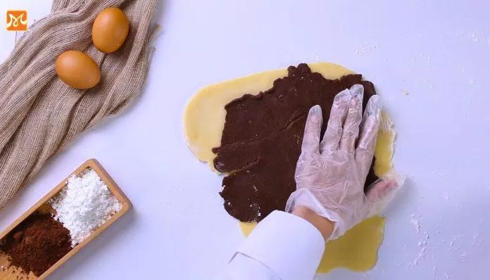 Đặt lớp bột cacao lên trên lớp bột. Nguồn: YouTube Hướng nghiệp Á Âu
