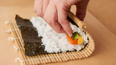 Các nguyên làm cơm cuộn rong biển được cho vào mành tre và cuộn lại để thành phẩm. (Nguồn: Internet) Các nguyên làm cơm cuộn rong biển được cho vào mành tre và cuộn lại để thành phẩm. (Nguồn: Internet)