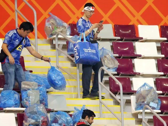 Cổ động viên Nhật Bản thu dọn rác tại sân vận động Khalifa sau chiến thắng lịch sử (Ảnh: Internet).