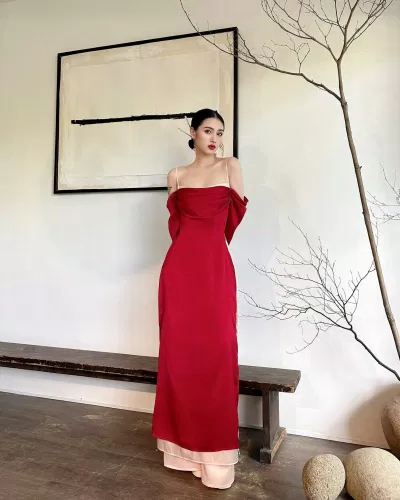 Một chiếc áo dài đỏ nhưng được biến tấu với phần áo trễ vai Một chiếc áo dài đỏ nhưng được biến tấu với phần áo trễ vai