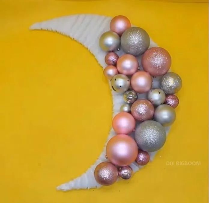 Đính xen kẽ những quả châu lên tấm bìa cứng hình mặt trăng (Nguồn: YouTube DIY BIGBOOM)