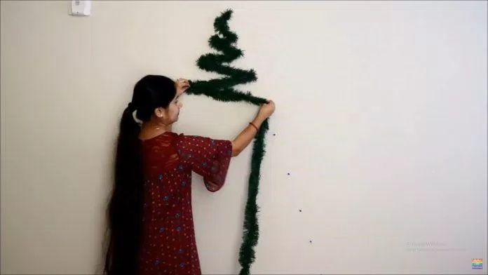Tạo hình cây thông trên tường với giấy kim tuyến và đinh ghim (Nguồn: YouTube MyTwoLittleSunshines) Tạo hình cây thông trên tường với giấy kim tuyến và đinh ghim (Nguồn: YouTube MyTwoLittleSunshines)