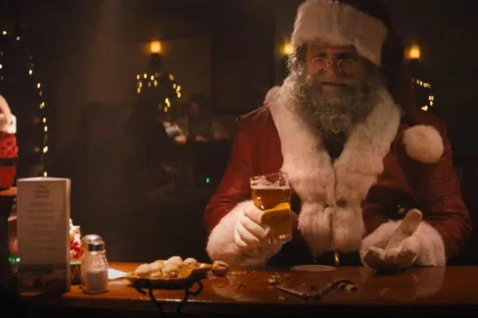 Ông già Noel "làm ấm người" bằng cốc bia trước khi đi phát quà. (Ảnh: Internet)